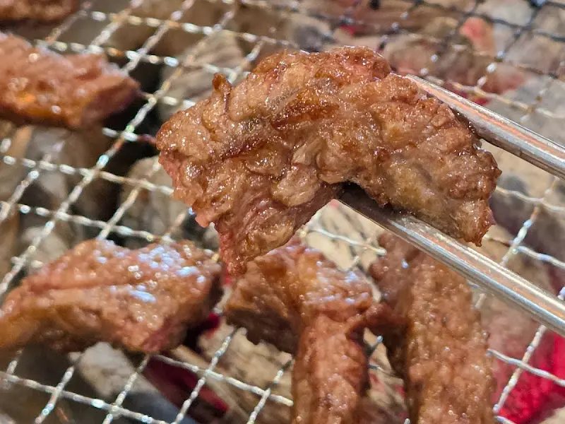 잘 익은 갈비살을 젓가락으로 집는 모습