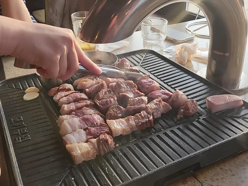 직원이 흑돼지를 굽는 모습