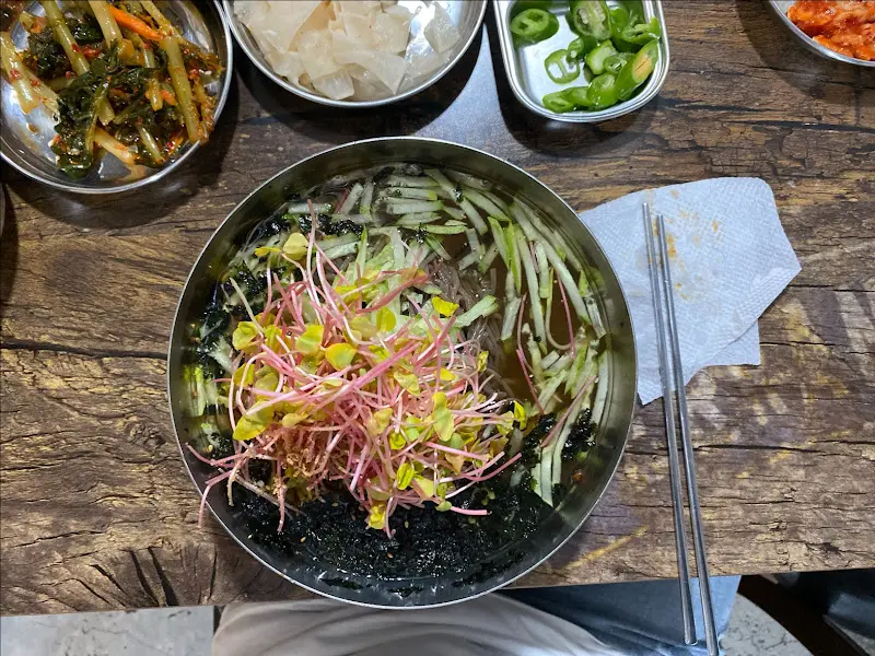 살얼음이 동동 뜬 냉육수를 부은 비빔막국수