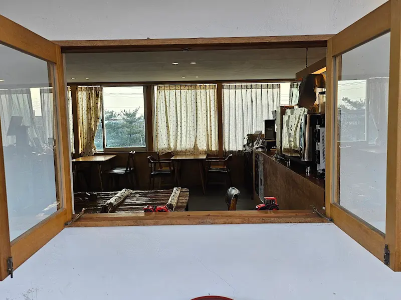 카페 내부에서 창밖을 바라본 모습. 나무 프레임의 큰 창문이 인상적이다.