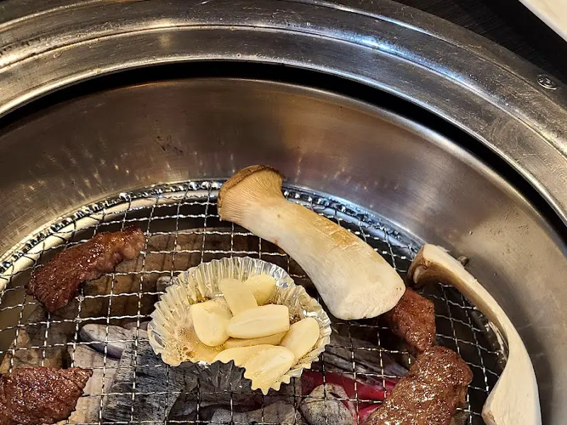 숯불 위에서 익어가는 고기와 버섯, 마늘