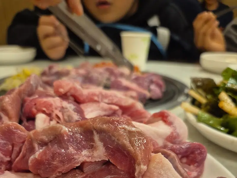 잘 구워진 뒷고기를 쌈에 싸서 한 입 가득