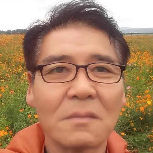 코스모스 밭을 배경으로 셀카를 찍은 중년 남성의 모습