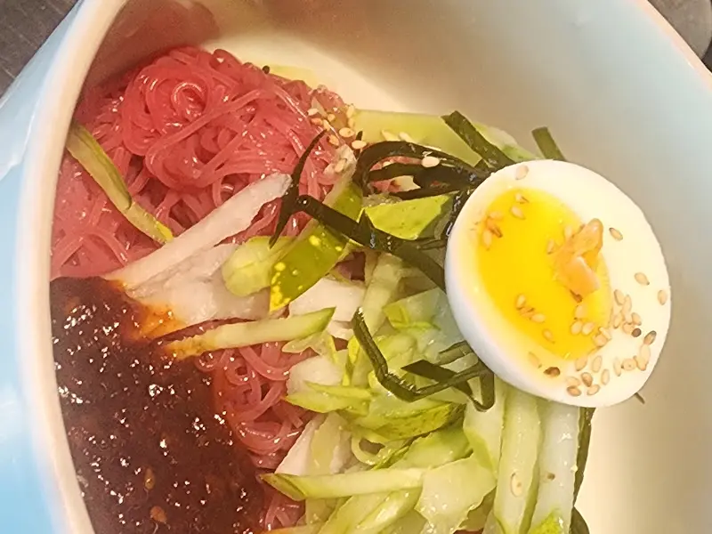 냉면에 올려진 채소와 계란 고명