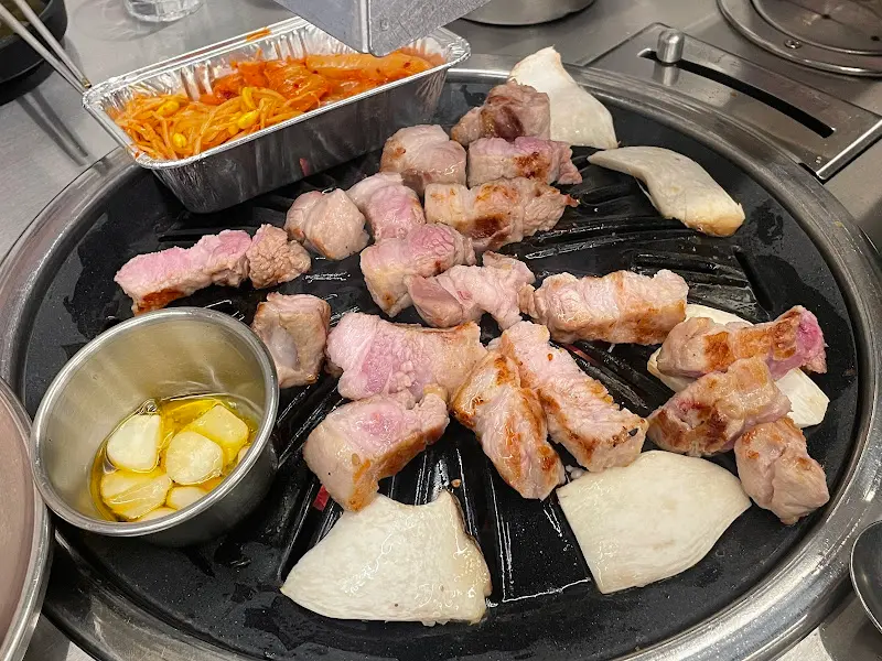 불판 위에서 구워지는 삼겹살과 김치