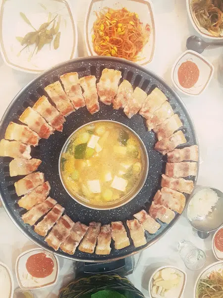 불판 위에 가지런히 놓인 삼겹살