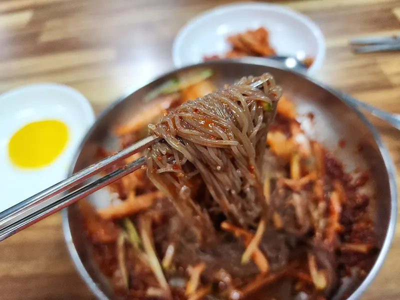 젓가락으로 들어올린 비빔냉면 면발