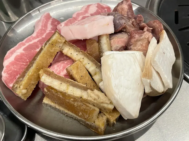 삼겹살과 갈매기살, 팽이버섯, 새송이버섯이 담긴 접시