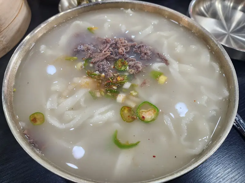 놋그릇에 담겨 나온 먹음직스러운 칼국수