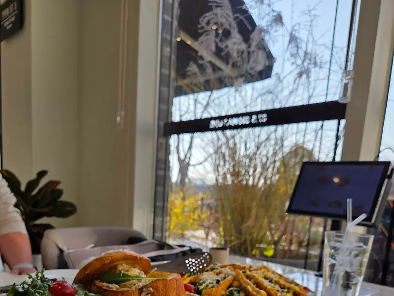 창가 좌석에 놓여진 샌드위치와 샐러드