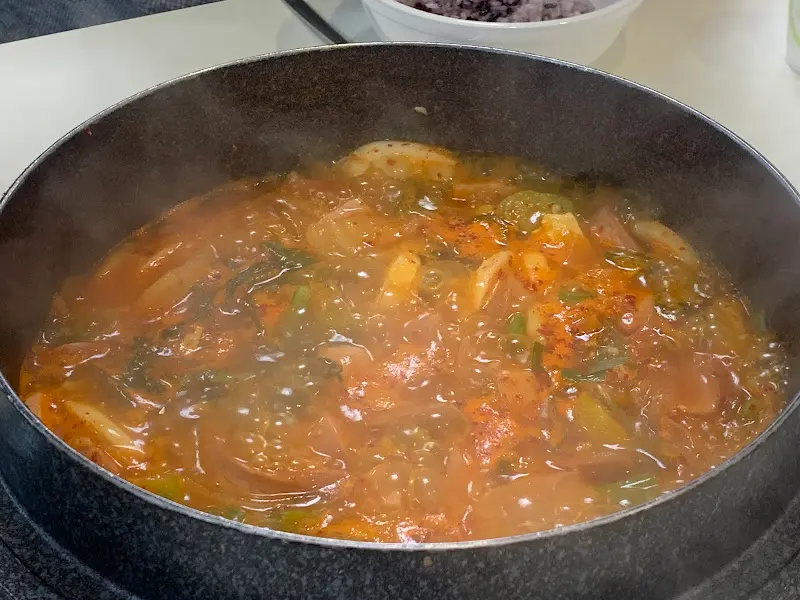 스페셜 부대찌개가 뚝배기 안에서 맛있게 끓고 있는 모습