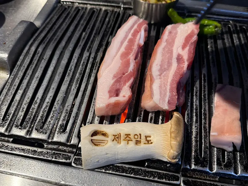 숯불 위에서 구워지고 있는 흑돼지 오겹살