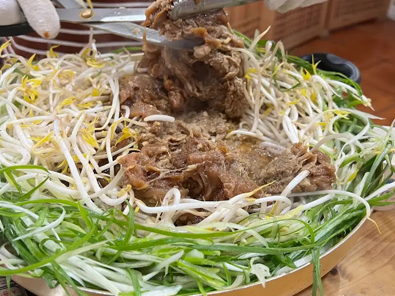 파불고기를 집게로 들어올리는 모습