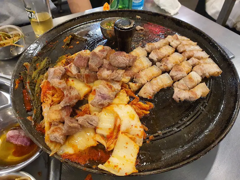 솥뚜껑 위에 구워진 목살과 김치