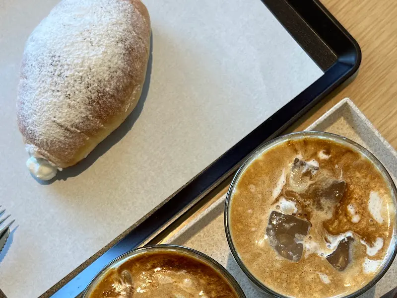 테이블 위에 놓인 아몬드 크림 라떼와 빵