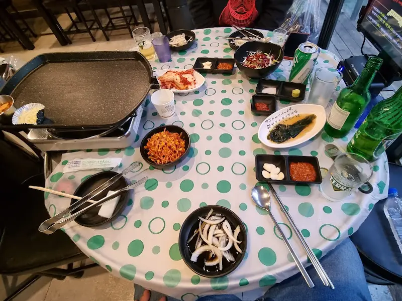 테이블 가득 차려진 밑반찬과 삼겹살