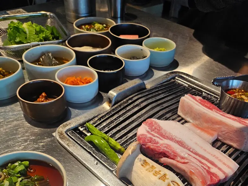 숯불과 흑돼지, 곁들임 채소가 놓인 테이블