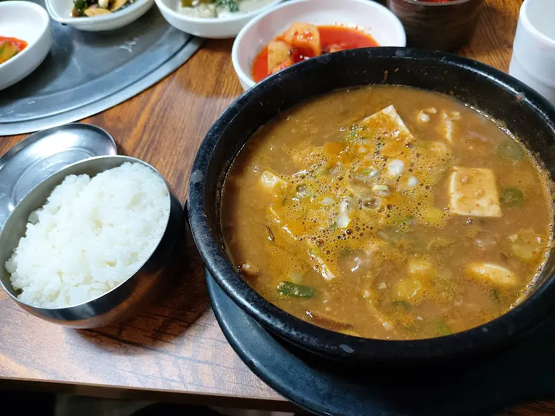 다양한 밑반찬과 청국장이 차려진 테이블의 모습