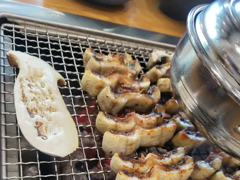 숯불 위에서 구워지는 장어와 버섯