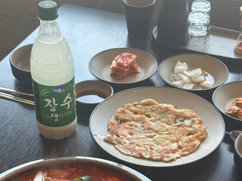 테이블 위에 놓인 기본 반찬과 서울장수 막걸리.