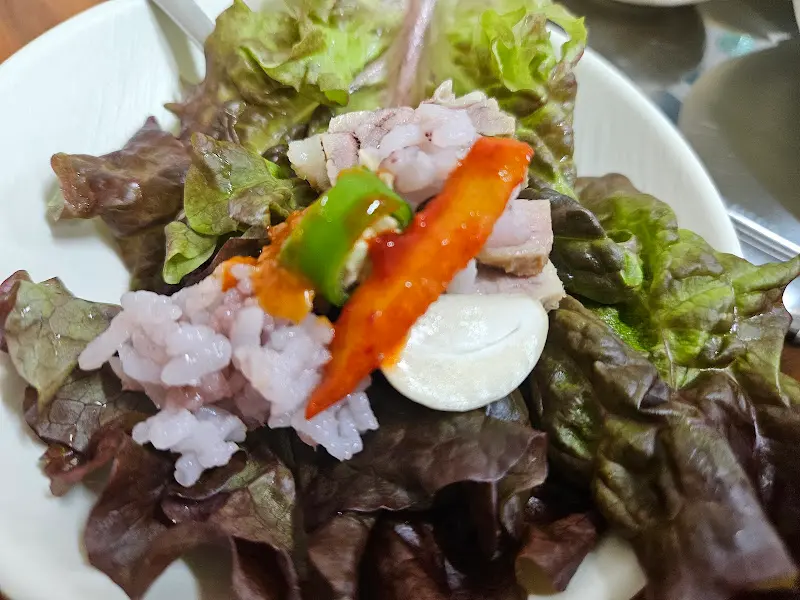 고기, 야채, 밥을 쌈으로 즐기는 모습