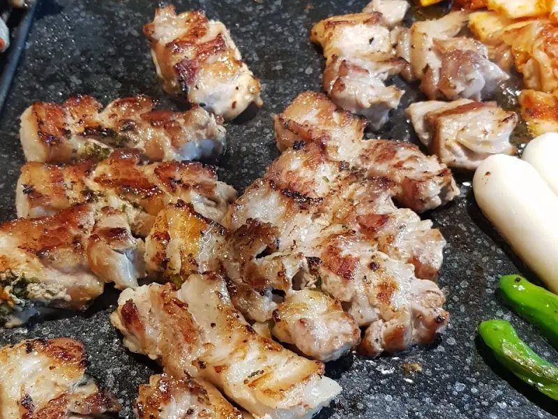 숯불 위에서 노릇하게 구워진 삼겹살