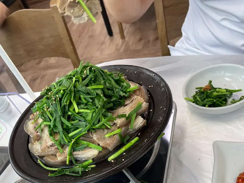 흑염소 수육 위에 부추가 듬뿍 올려진 모습