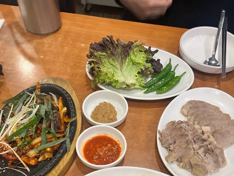 쭈꾸미 볶음, 쌈 채소, 수육 등이 테이블 위에 놓여 있는 모습