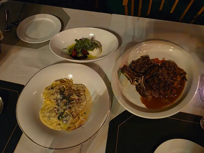 테이블 위에 놓인 파스타, 샐러드, 스테이크