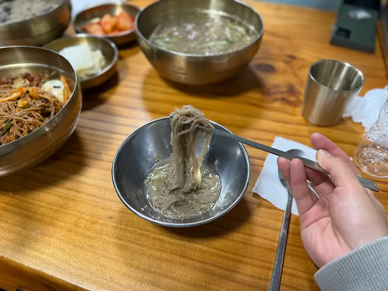 막국수 면을 들어올리는 모습