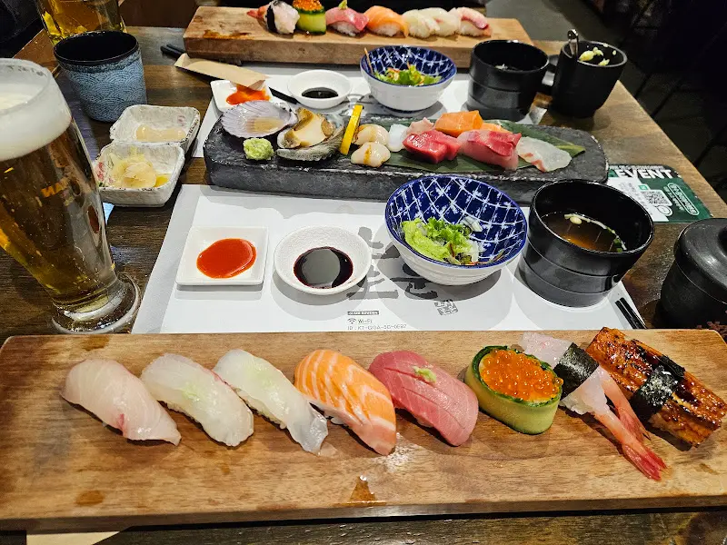 신선한 해산물과 초밥이 나무 도마 위에 정갈하게 담겨 있는 모습