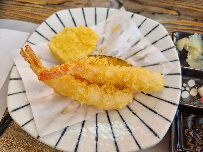 튀김옷을 입은 새우와 단호박 튀김이 접시에 담겨 있는 모습