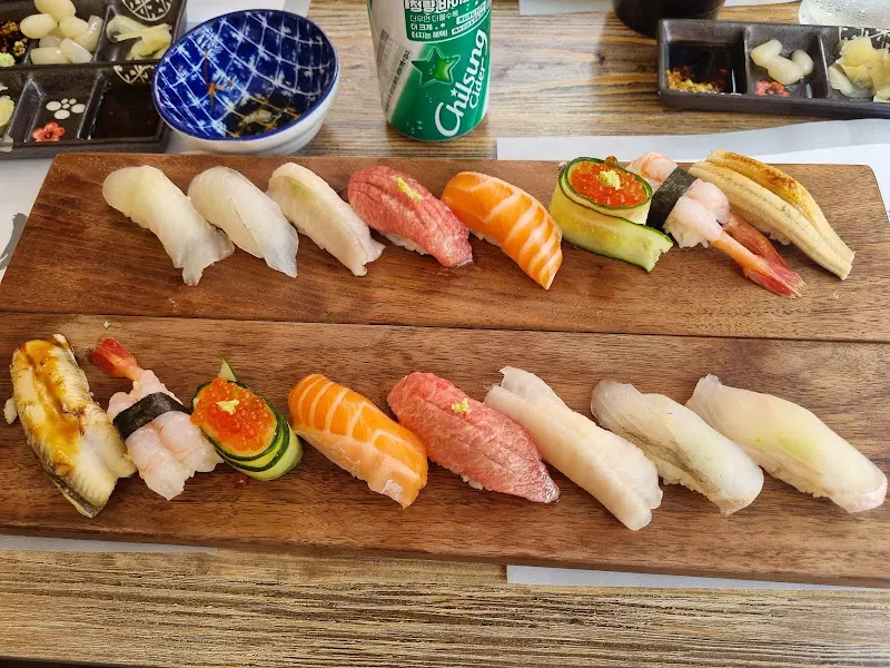 다양한 종류의 초밥이 나무 도마 위에 정갈하게 놓여 있는 모습