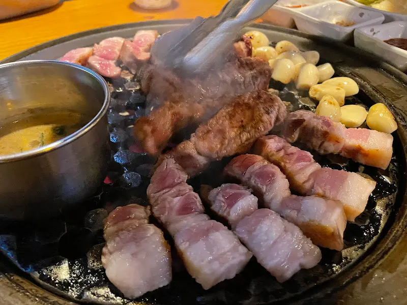 숯불 위에서 노릇하게 익어가는 오겹살과 목살