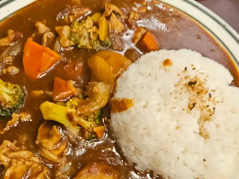 밥 위에 윤기 흐르는 카레가 듬뿍 올려진 모습