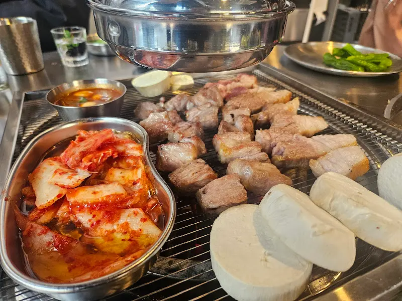 숯불 위에서 구워지는 삼겹살과 김치