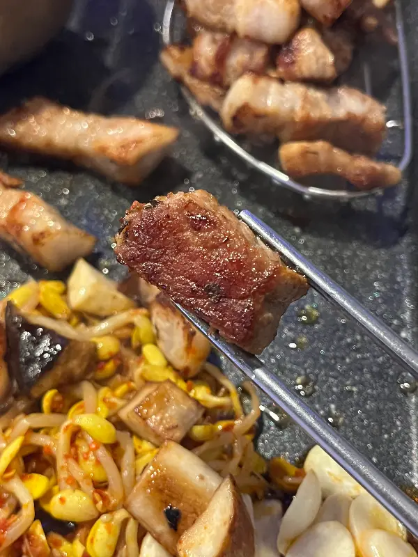 두툼하게 썰린 삼겹살과 목살이 불판 위에서 익어가는 모습