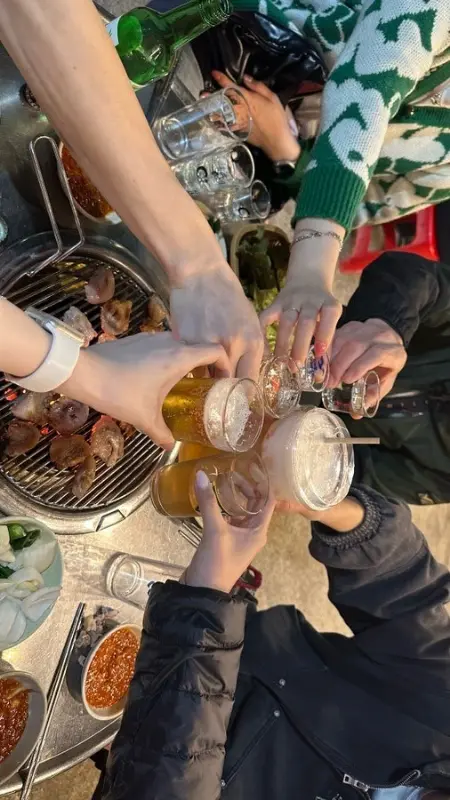 술잔을 부딪히며 즐거운 시간을 보내는 사람들