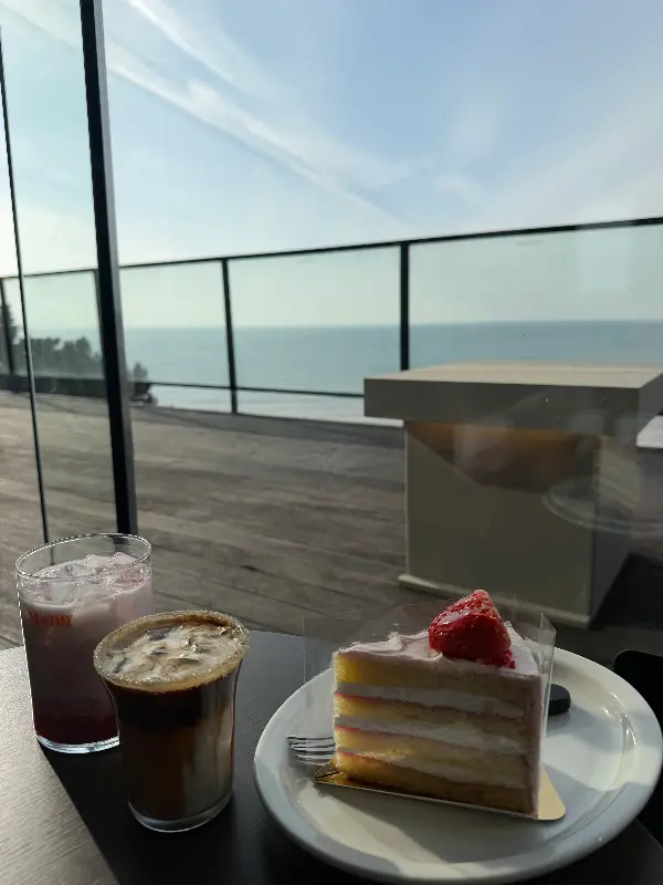 음료와 케이크를 배경으로 펼쳐진 오션뷰