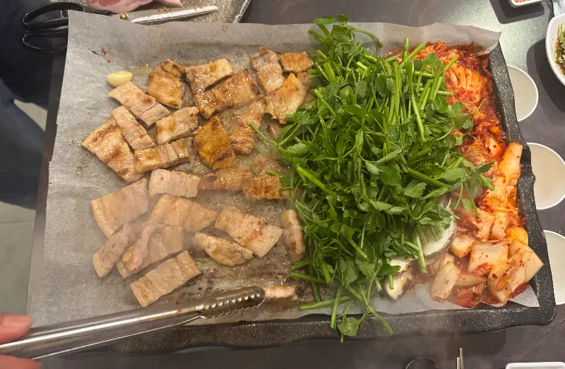 구워지고 있는 삼겹살과 미나리