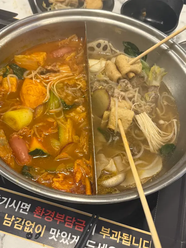 두 종류의 육수에 샤브샤브 재료가 담긴 모습
