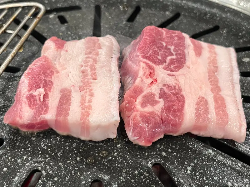 석쇠 위에서 노릇노릇 구워지고 있는 흑돼지 삼겹살의 모습