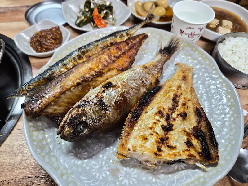 솥뚜껑 위에 올려져 따뜻함을 유지한 채 제공되는 생선구이