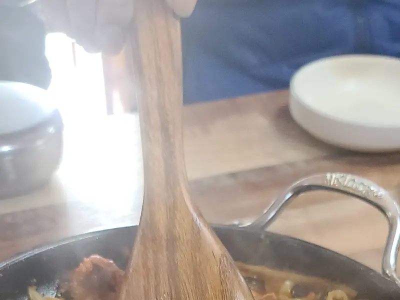 돼지 주물럭 볶음을 나무 주걱으로 휘젓는 모습