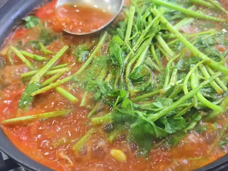 국자로 닭내장탕을 뜨는 모습