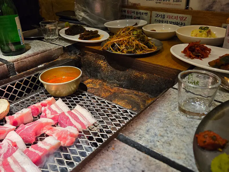 숯불과 밑반찬, 된장찌개가 차려진 테이블