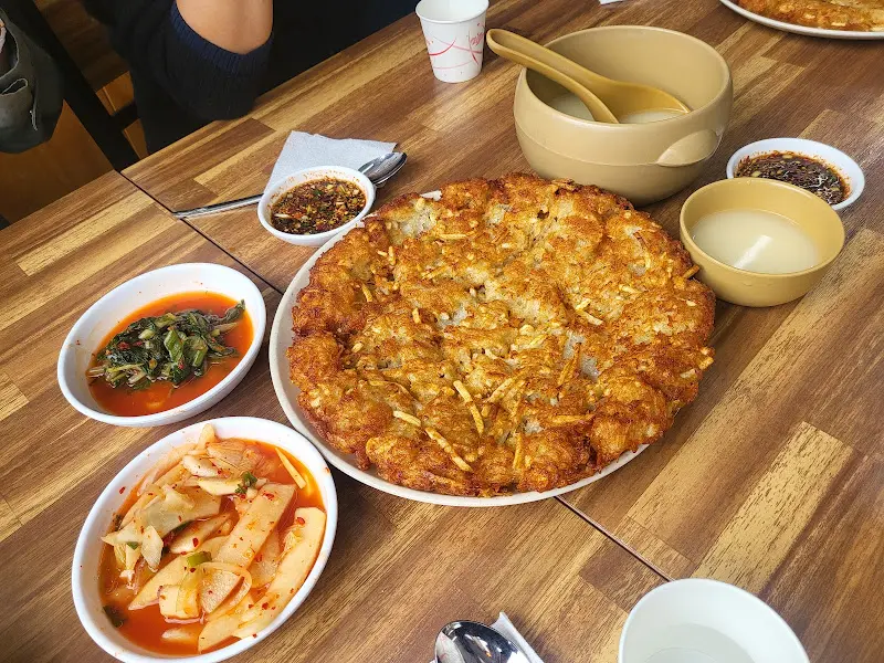 테이블 위에 놓인 감자전과 막국수, 곁들임 찬