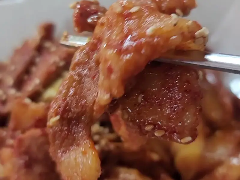 젓가락으로 집어든 제육볶음