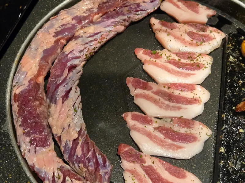 불판 위에서 구워지고 있는 얇게 썰린 고기