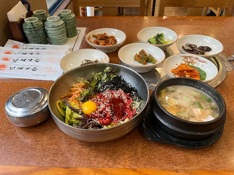 정갈하게 차려진 육회비빔밥과 다양한 반찬들